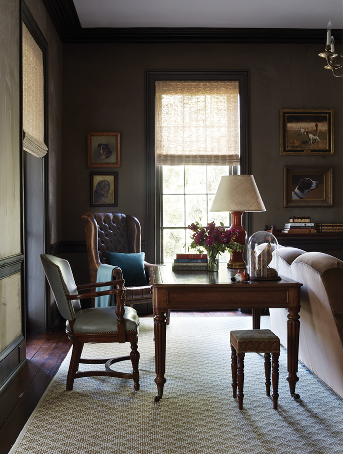 Moody Hues: This grand library shares the home’s second floor with the primary bedroom suite. Situated directly above the dining room at the front of the house, it mimics that room’s rich color palette and is similarly brightened by ample natural light along with the addition of a large ivory and olive wool area rug from Eve and Staron.