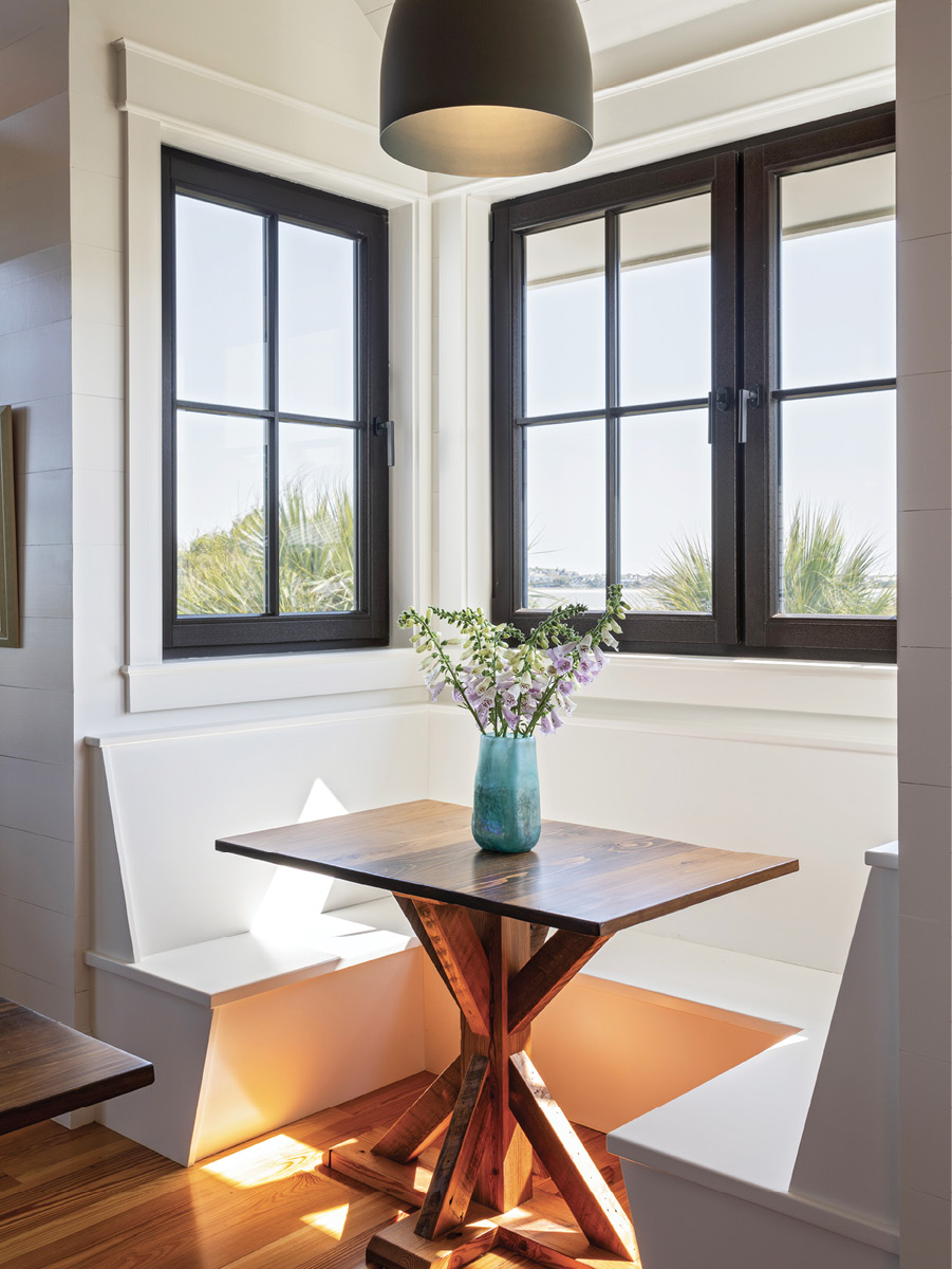 DINNER A DEUX—OR MORE: The dining table extends into this breakfast nook, creating a space for everyday use, while providing plenty of room for a large family gathering when connected to the main table. The floors throughout are reclaimed heart pine from a former denim factory in North Carolina.