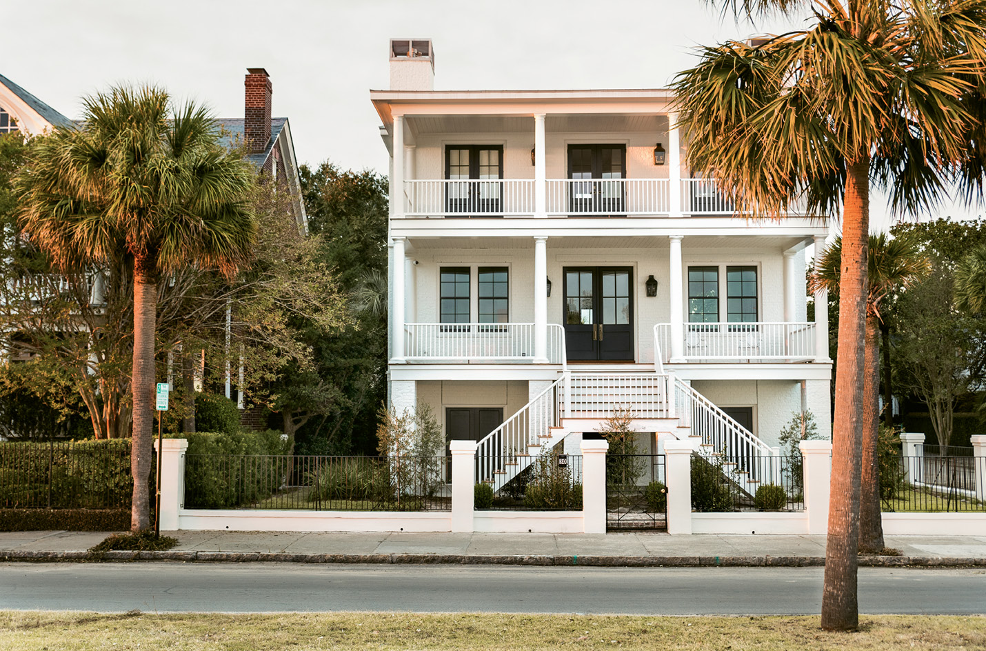 With its double porches, elevated entrance, and graceful symmetry, the home’s façade nods to antebellum architecture, but its clean lines and black window mullions are decidedly modern.