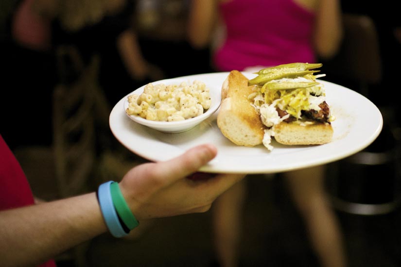 Home Team BBQ offers a smoked sausage sandwich with pickled okra and mac-n-cheese on the side