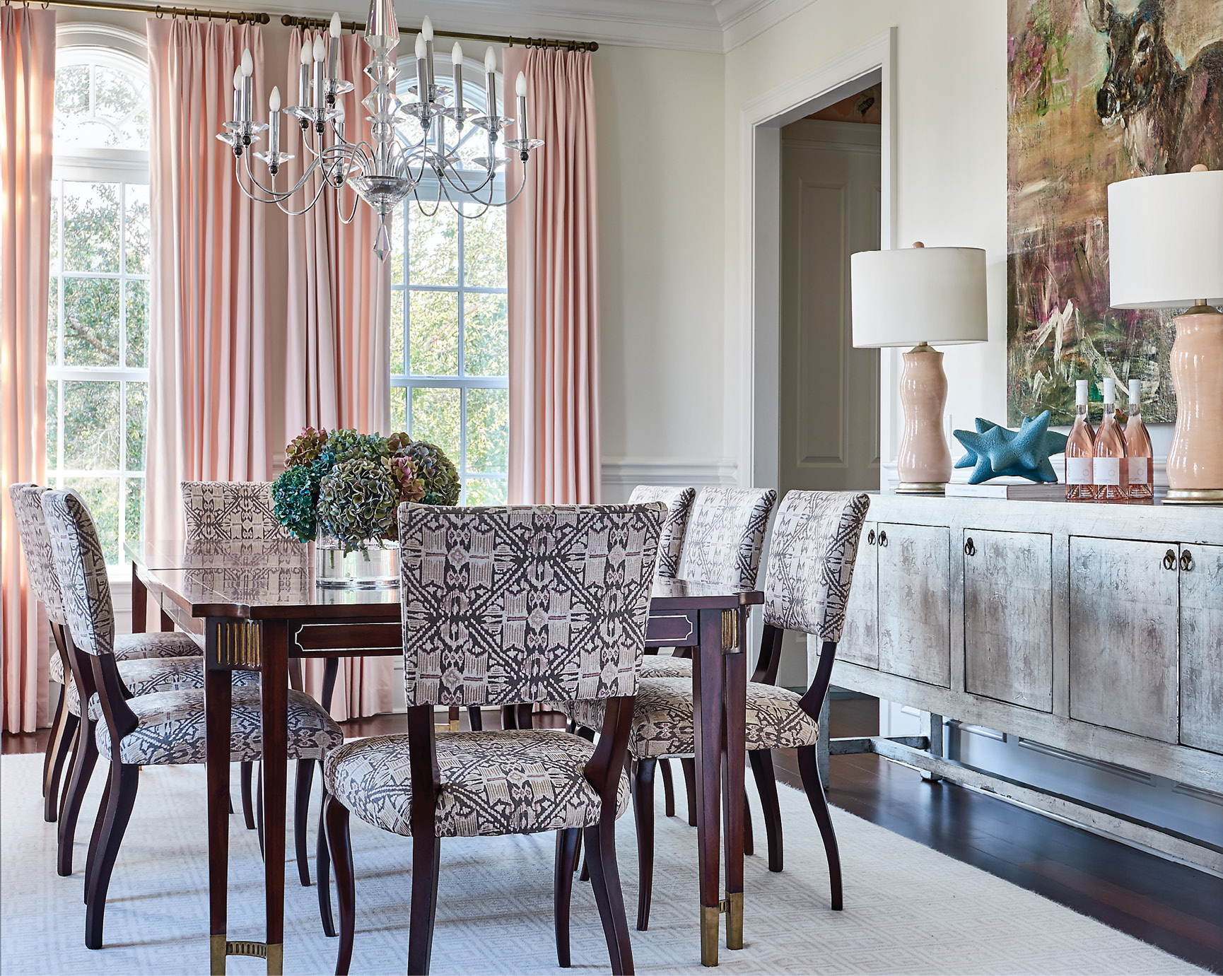In the dining room, pastel pink drapes from Greenhouse Fabrics continue the light, feminine feel, bringing playful hues to the more formal space.