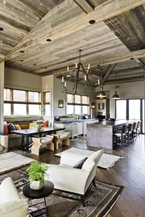 Up In The Air: A rustic, barnwood ceiling and antique Oushak and Moroccan rugs offset the kitchen’s cool, industrial sensibility, defined by a concrete island and countertops and Visual Comfort pendant lighting.