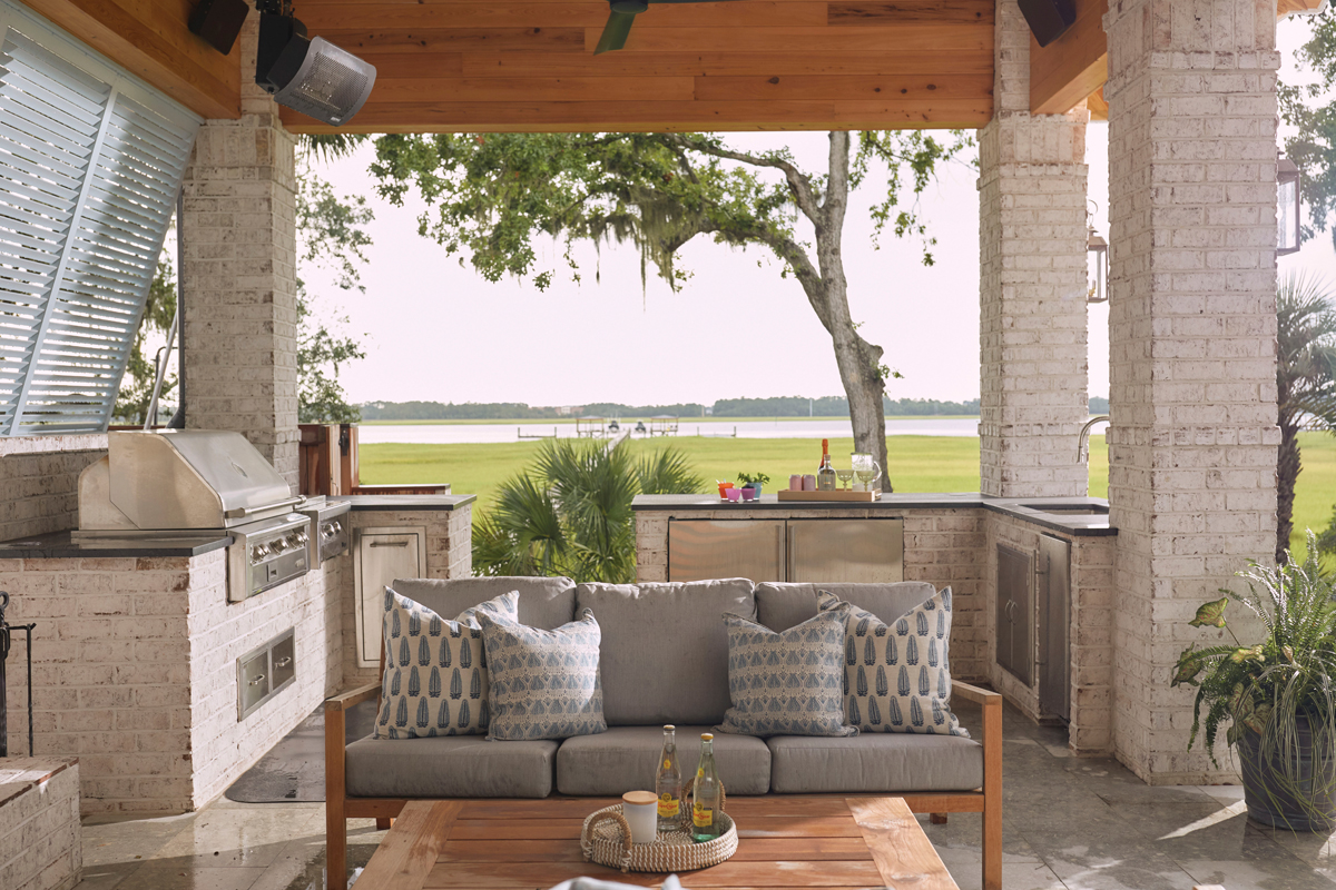 Catch &amp; Relax: The fully equipped kitchen from Plugs Appliances allows for cleaning and cooking the day’s catch. The adjacent outdoor furnishings from Teak + Table are accessorized with Walter G pillows from Celadon Home.