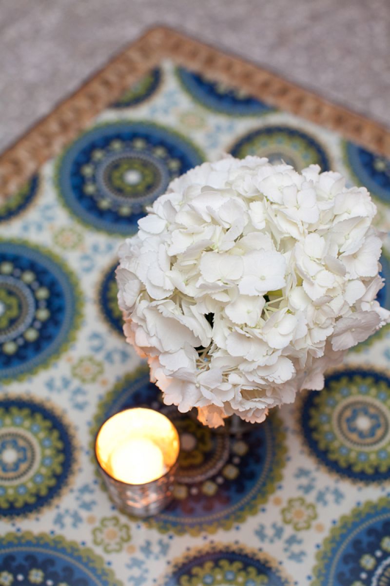 TOP THAT: Lounge tables were topped with the paisley pattern found throughout the reception. Accents were kept simple—white hydrangea and small mercury glass votive holders—as to not compete with the bright design.