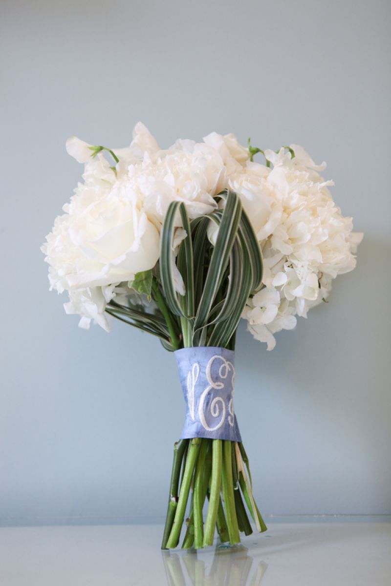 SOMETHING NEW: The bride’s white rose and hydrangea boutique was wrapped in a cornflower blue dupioni silk sash embroidered with her new initials.