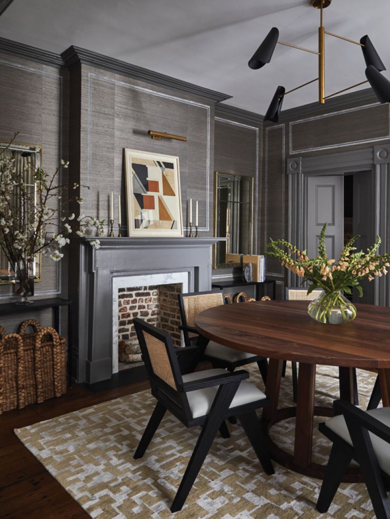 Shades of Gray: The custom walnut dining table is surrounded by six “Flora” dining chairs from Four Hands, their black oak and cane accents providing contrast for the room’s focal point. Two brass, antiqued mirrors by local artisan Bob Hines add the illusion of more space. As the sole light source, the “Tresa” chandelier from Visual Comfort creates a cozy glow at night.