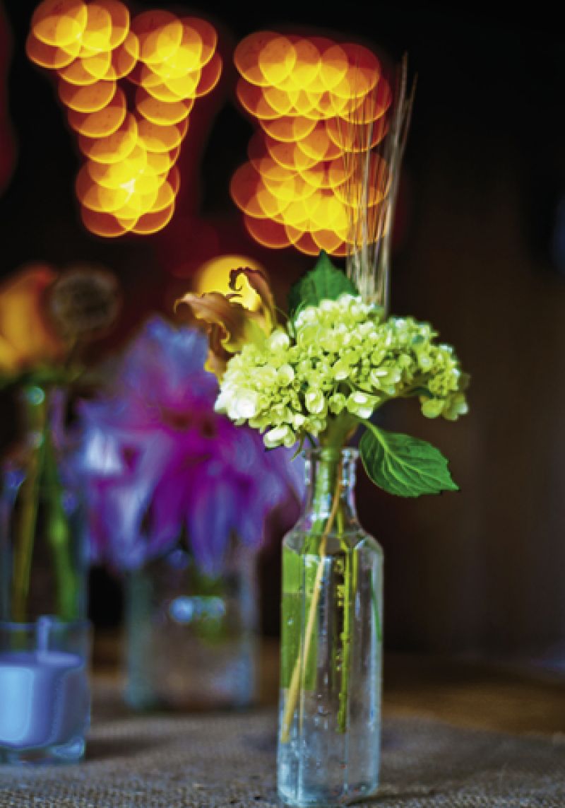 GO GREEN: Vintage soda and tincture bottles served as vases to hold stems of green hydrangeas and persimmon-colored lilies.