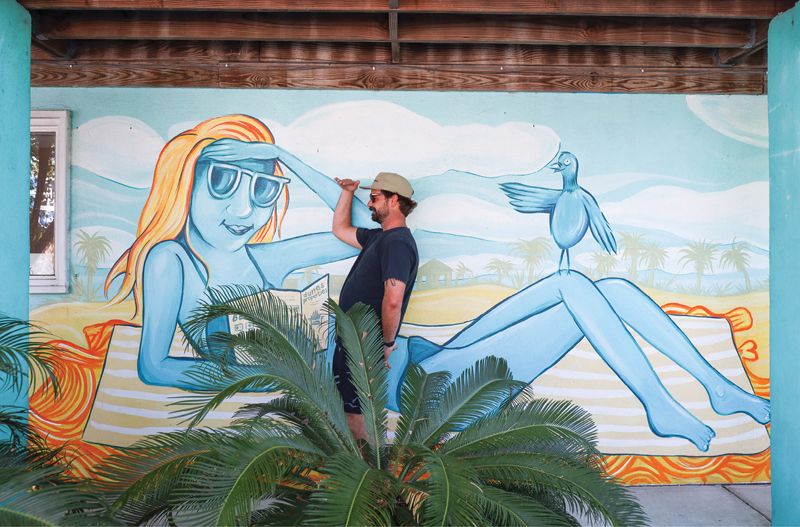 Artist Chris Kemp is the face behind this mural at McKevlin’s Surf Shop and the cover art for each issue of The Folly Current. The April issue celebrated the 20th anniversary of Lost Dog Cafe.