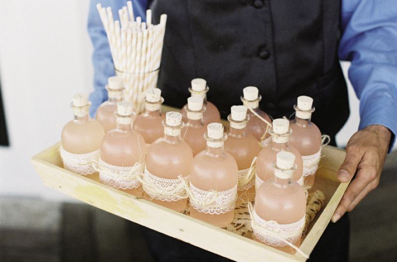 SIGNATURE SIP: Soirée filled small corked glass bottles with pink Lowcountry Lemonade (made with peach schnapps), tied them off with lace, and served each with a striped straw.