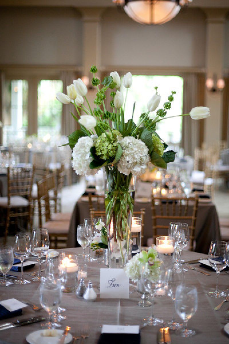 FRESH EFFECT: Beige table linens set the backdrop for arrangements of white tulips and white and green hydrangea.