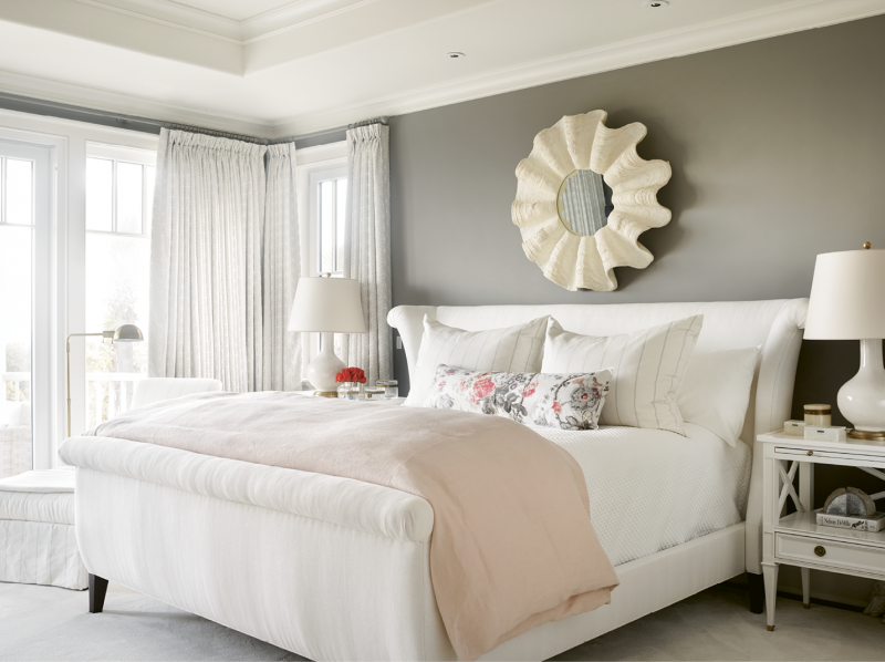 In the master bedroom, walls covered in Farrow and Ball’s “Mole’s Breath” and drapes made with light grey Shumacher fabric ground the room’s blush accents. The lamps are from Circa Lighting.