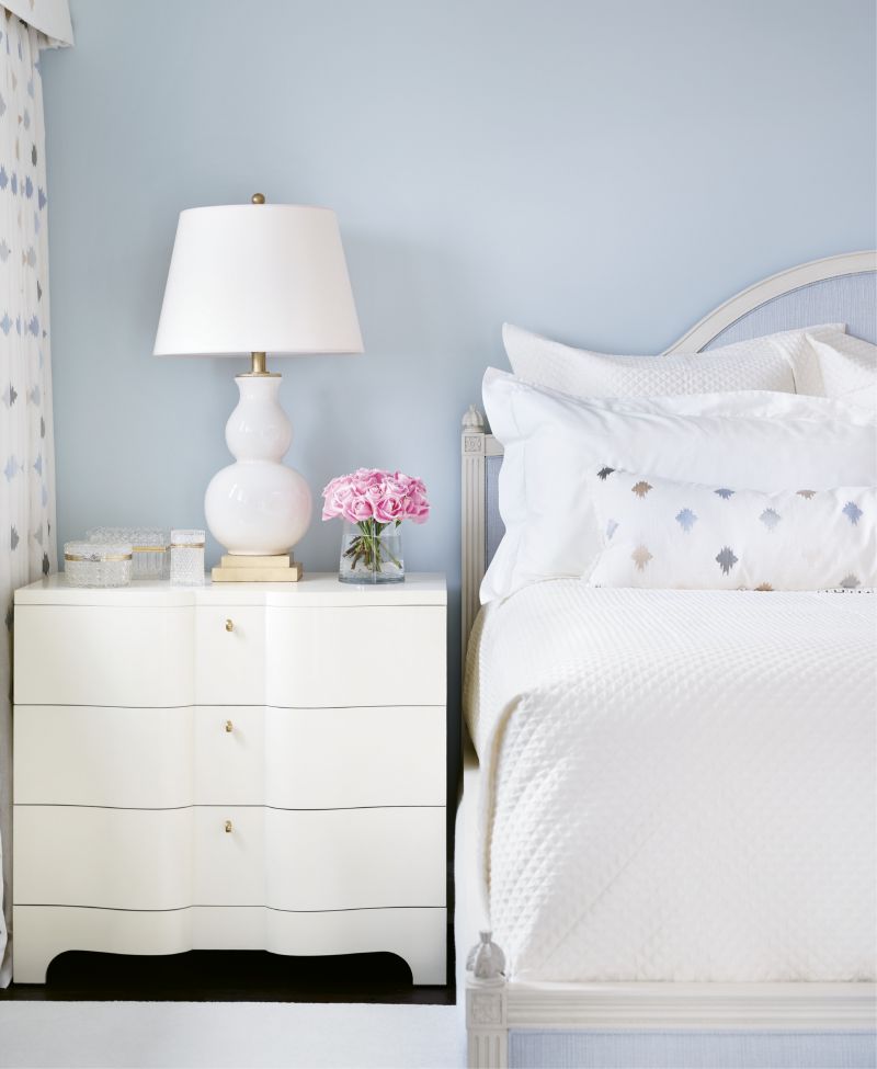 Another guest room offers a soothing blue palette echoed in the upholstered headboard.