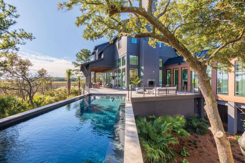 Serene Dream: The home’s positioning takes full advantage of the lot’s unusual configuration, with a narrow street frontage and a wide marshfront. Van Dalen expertly designed the structure around existing trees so the home is shaded and private while capturing the views. The elevated pool was installed by Aqua Blue Pools.