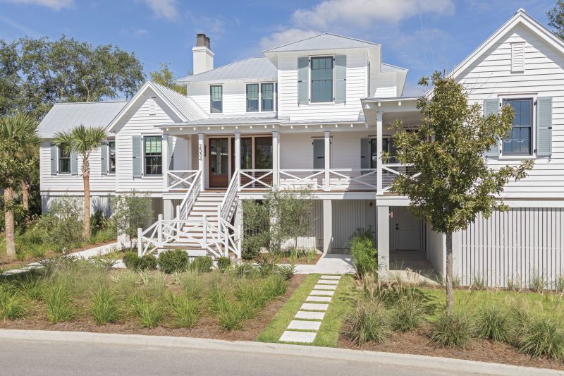 Family Time: New England natives Jamie and James Pagliocco built this marshfront Kiawah River house as a coastal Southern outpost for the entire family to gather, as well as a home base for the soon-to-be retirees. Slate-blue shutters (painted in Benjamin Moore “Brewster Gray”) mirror the nearby water, while native grasses and trees add a verdant touch.