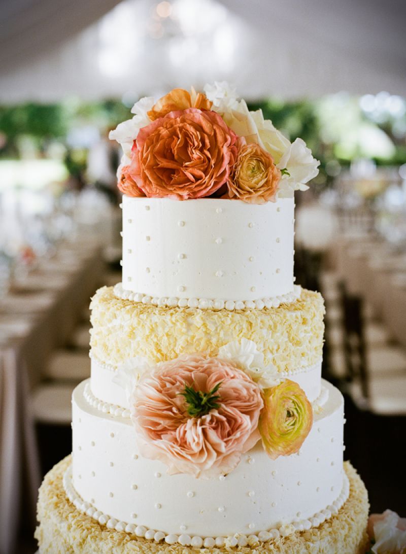 DRESSED TO IMPRESS: Bright ranunculus and cabbage roses accented the four-tiered, textured confection by Fish Restaurant.