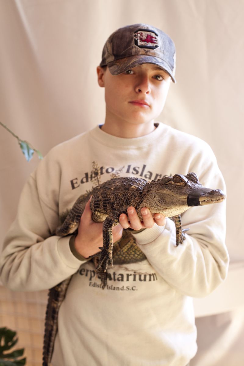 Michael Mizell carries an American Alligator for spectators to see up close.