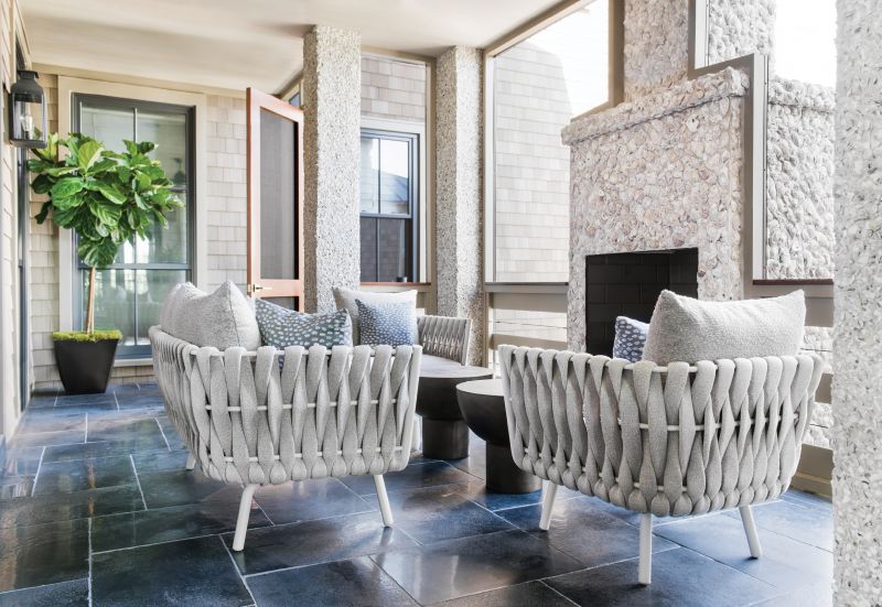 Shell Game: Stainless steel, textile-wrapped lounge chairs and a sofa from JANUS et Cie complement the simple yet dramatic second-floor porch, with its hand-thrown, oyster-shell fireplace and limestone flooring.
