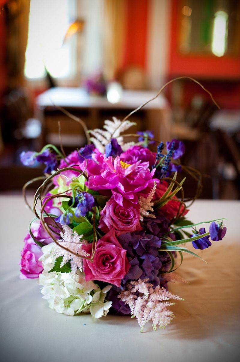 CONTROLLED CHAOS: Wild arrangements in bold colors added an “enchanted forest” feel to the vintage-glam reception.
