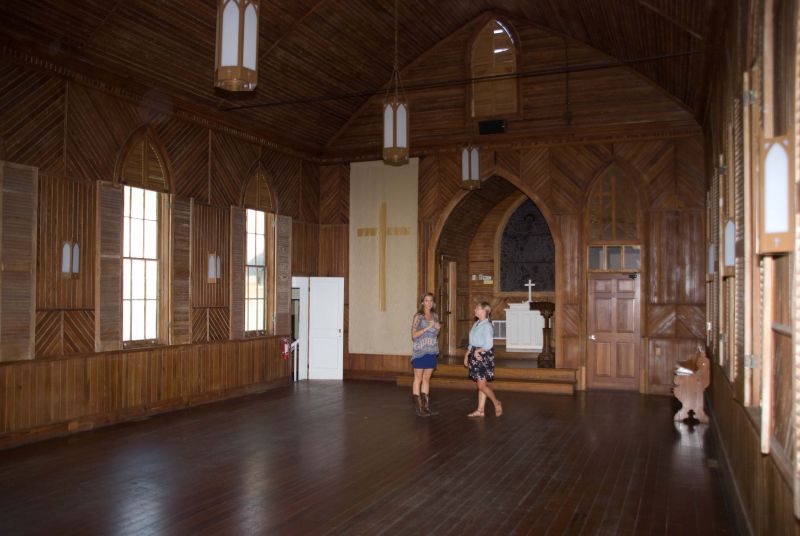 Molly and Lizzie take a break after clearing the chapel of tables and chairs. The paint was stripped off in the 1970s and it’s stayed honey-bare ever since.