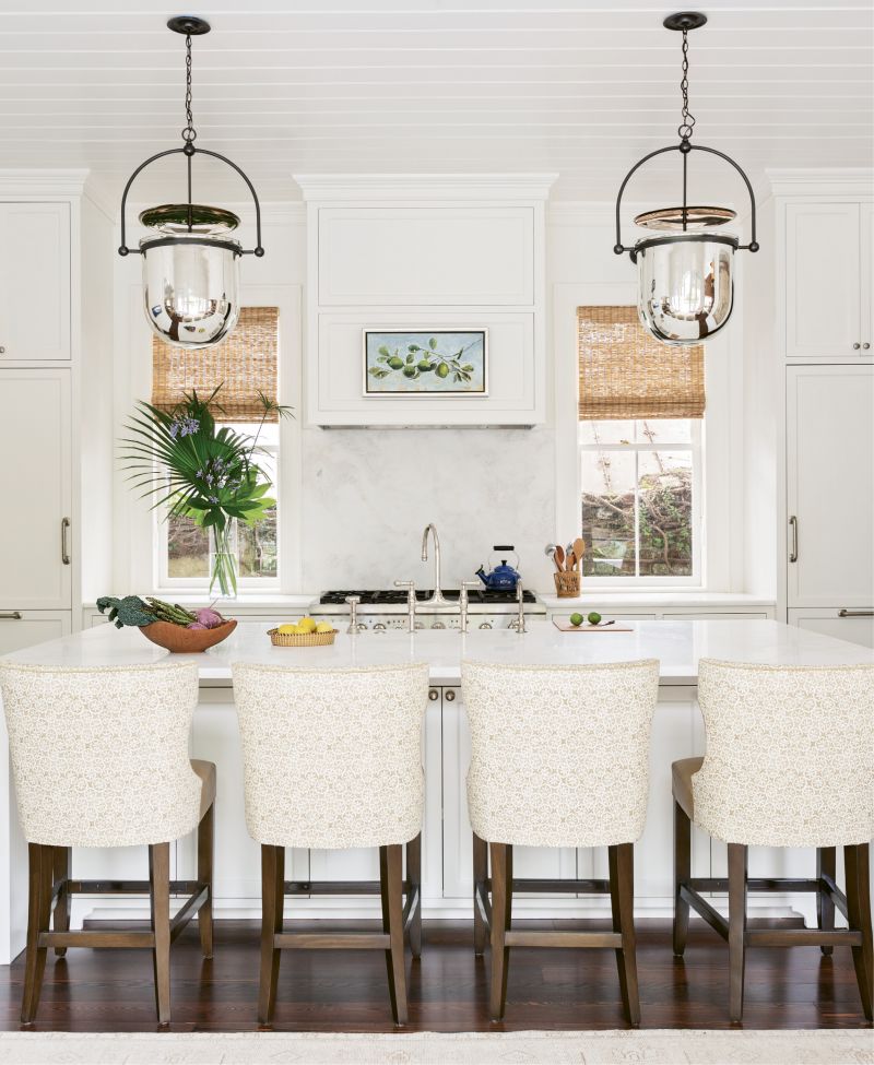 SIMPLE SYMMETRY: Dominated by a large white Namib marble-topped island, ideal for gathering the family as well as spreading out the newspaper, the kitchen is literally and figuratively the heart of this home. A pair of “Urban Smokebell” lanterns from Urban Electric add a grand scale and align perfectly with the two newly discovered windows, previously covered by cabinets.