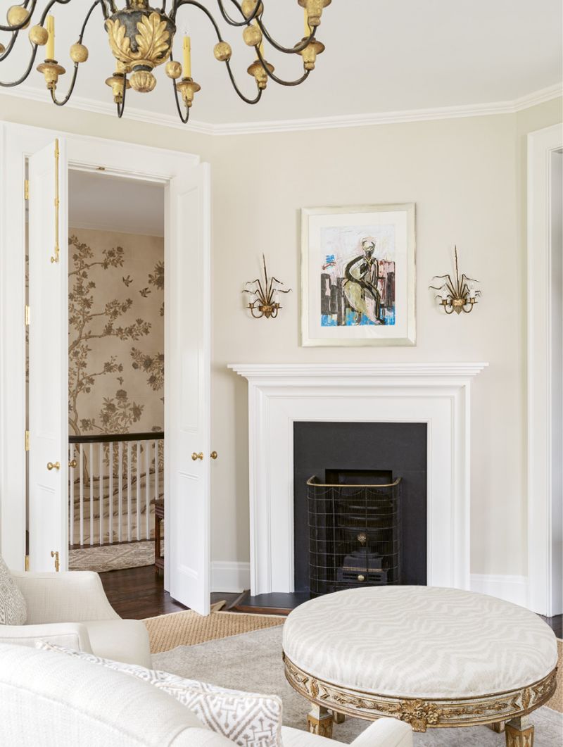 A pair of early-20th-century Spanish Barcelona gilt tole sconces from David Skinner Antiques flank an Anne Darby Parker oil above the fireplace.