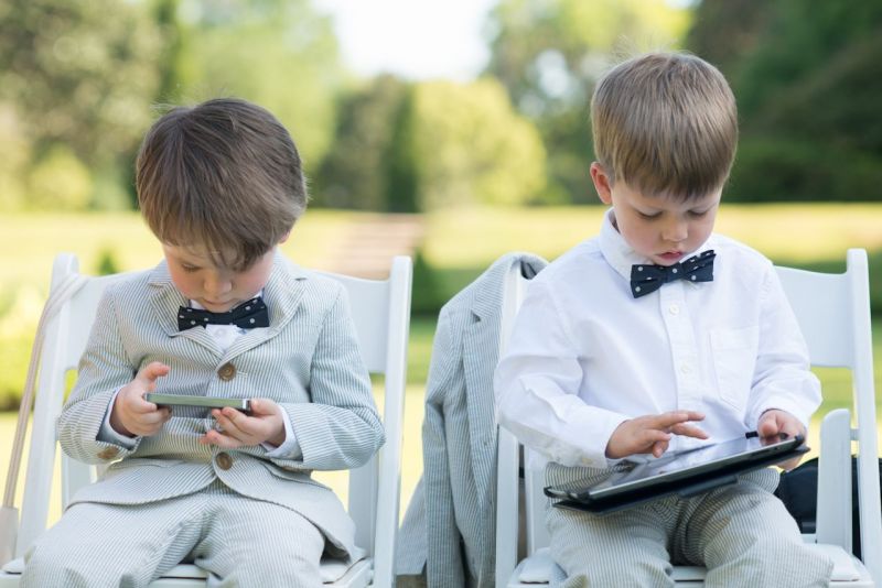 OUT-OF-OFFICE: “We really wanted all of our guests to feel as though they were on vacation,” says D’Anne. Relaxed in their dapper seersucker suits, tech-savvy ring bearers Liam Green and Keenan Ward had no problem following their Aunt’s request, plugging in some playtime before the ceremony.