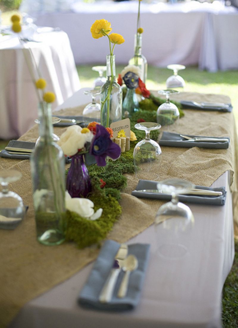 DINING OUT: Burlap table linens, repurposed wine bottles, wildflowers, and colorful vases gave the reception spreads a cheerful, earthy feel.