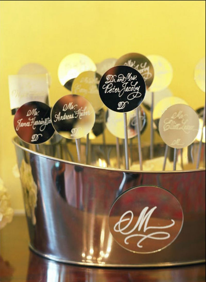 MIRROR, MIRROR: For an airy effect, table assignments were calligraphed onto mirrored circles, which Soirée attached to silver sticks and presented in metal baskets.