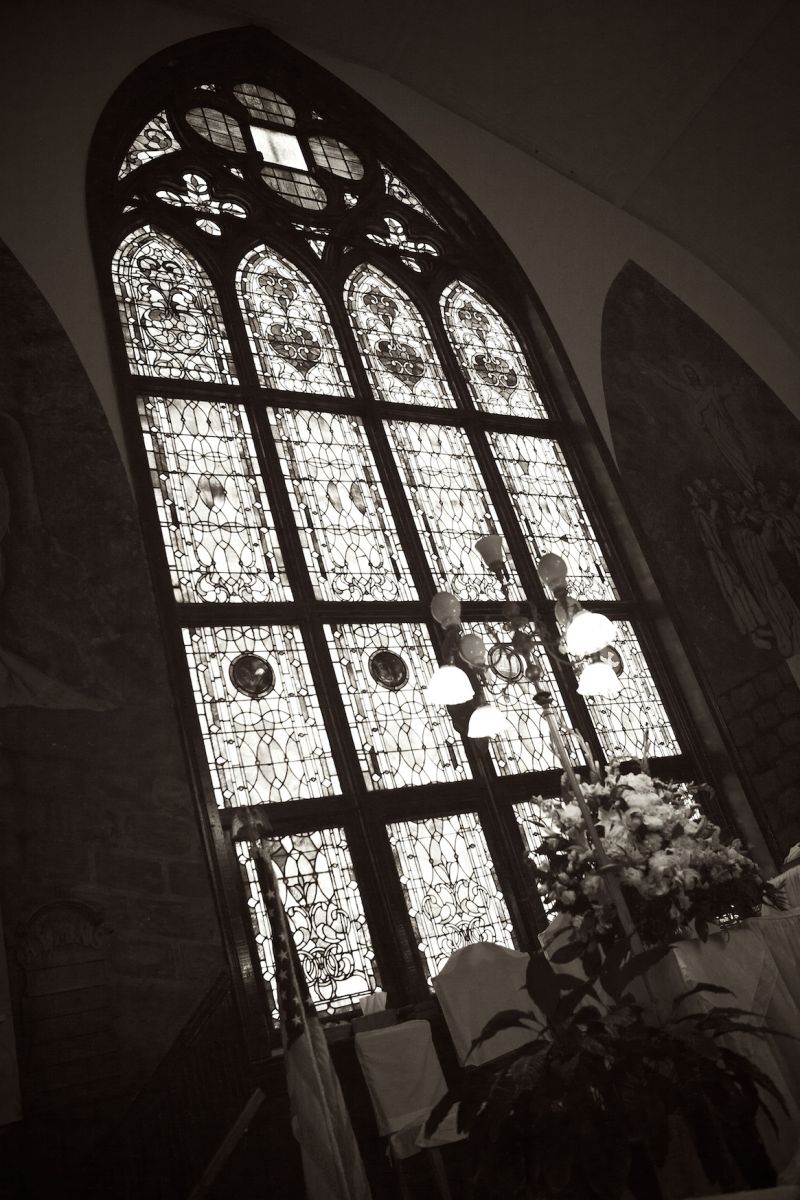 SACRED BEAUTY: An exquisite floor to ceiling stained glass window, located directly behind the altar, filled the church with lots of natural light for the afternoon ceremony.