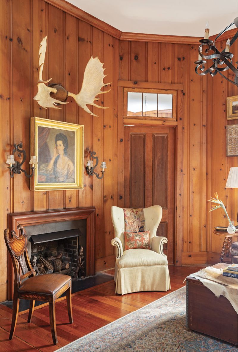Warming Trend: The wood-paneled den was completed in the 1950s by then-owner author Paul Hyde Bonner for his study. The pine comes from a mill in Summerville that’s still operational. Ralph sourced a few accessories to complement the warm room, including a gold-leaf-framed portrait from 17 South Antiques and a vintage chair from Antiques of South Windermere. She livened up the space with fun fabric from Rogers &amp; Goffigon and Cindy Barganier Textiles for the sofa pillows.