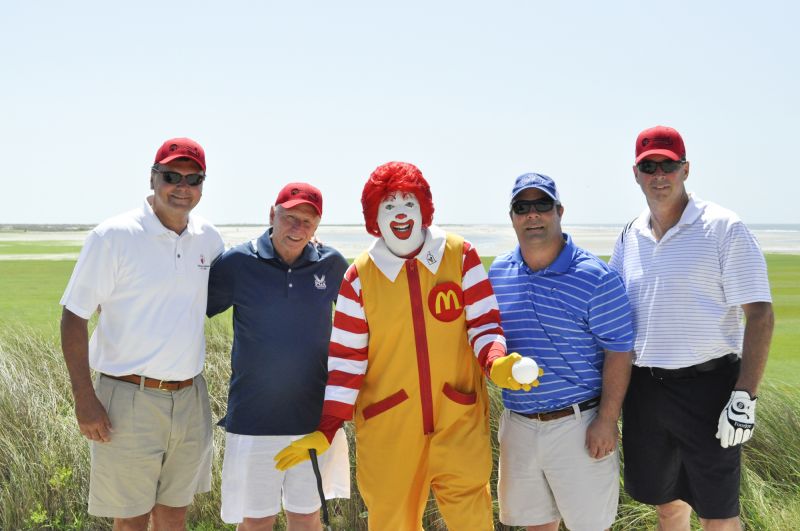 Golf participants posed with Ronald McDonald before they teed off.