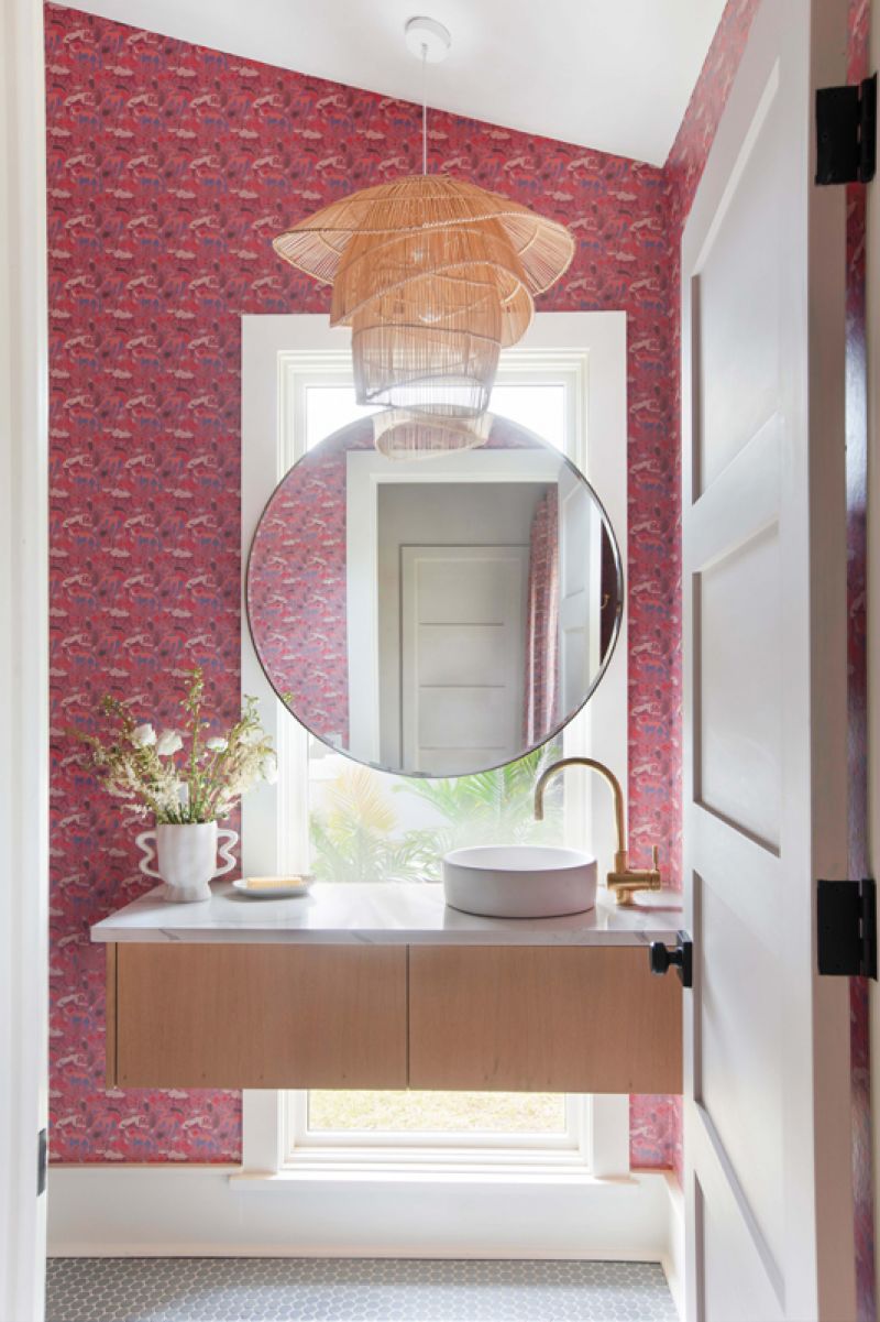 It’s paired with “Rhino, Fuchsia” drapes, a pattern repeated in the adjoining bathroom.