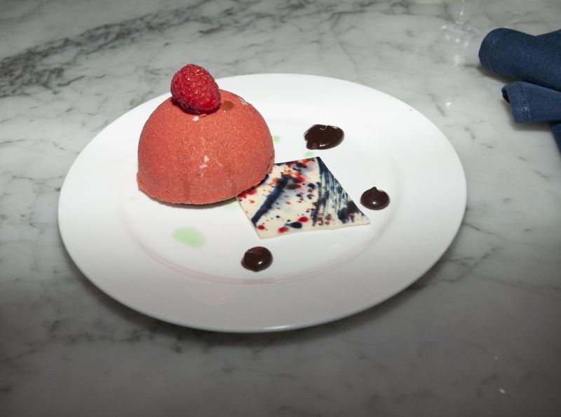 Raspberry mousse with a flourless chocolate sponge, raspberry filling, and chocolate fudge sauce, artfully crafted by Little Chef Isabella Hurd and Big Chef Richard Plaistowe of Halls Management Group.