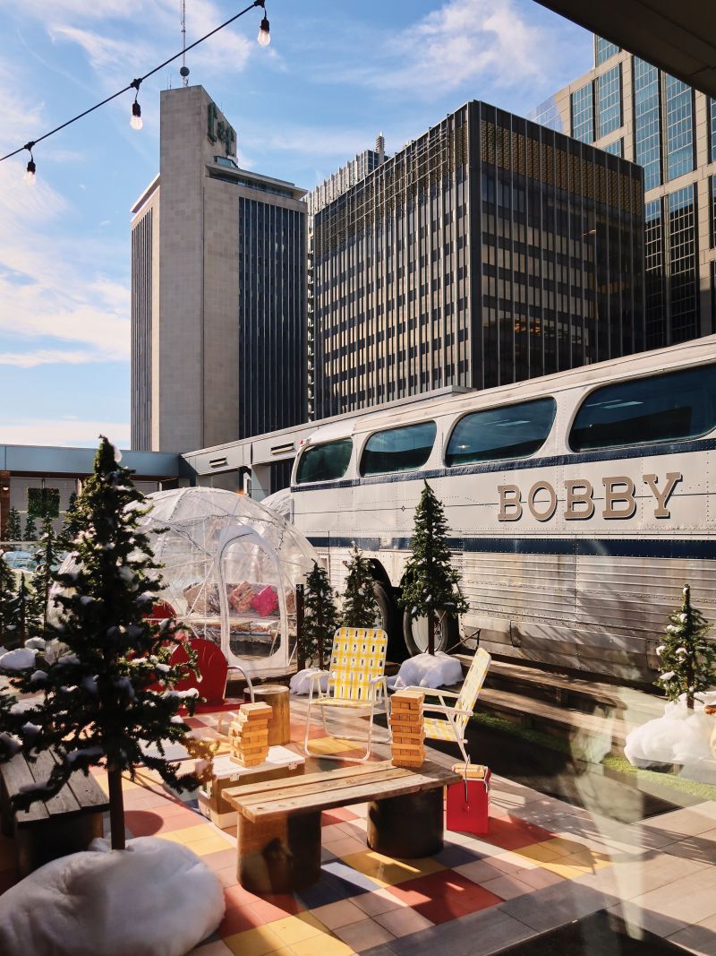 The rooftop at Bobby Hotel offers food and drink (including hot chicken) and a vintage Greyhound tour bus with lounge seating inside. This winter, “igloos” and trees were added for seasonal fun.