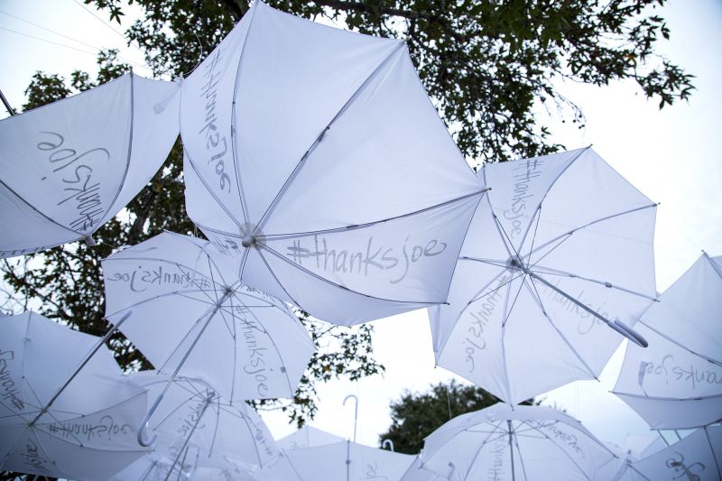 Umbrellas hung from the trees with the #thanksjoe hashtag written on them.
