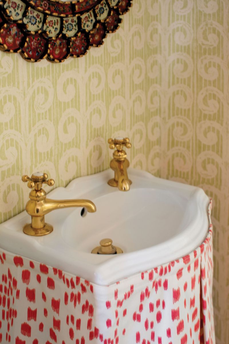 Space Saver: A unique addition to the dining room is this powder room, where a tiny sink and toilet have been squeezed into a closet. Caitlin made the most of this unusual positioning with a playful wallpaper, “Fern” by Blithfield, and sink skirt in Brunschwig &amp; Fils “Le Touches” fabric.
