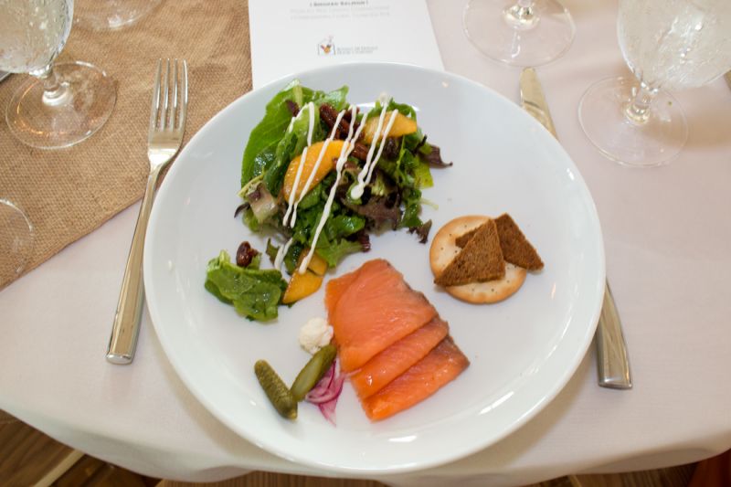Tristan Catering and Events plated a smoked salmon and field green salad with Carolina peaches, goat cheese, spiced pecans, and champagne vinaigrette.