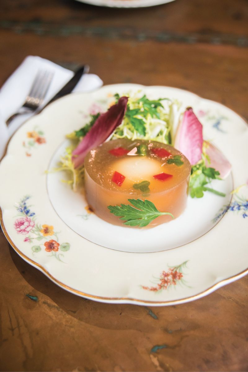 Suspended Animation: A soft-boiled egg afloat in a chicken-stock aspic gains playful panache from red-pepper diamonds and cucumber clubs in the oeufs en gelée appetizer.