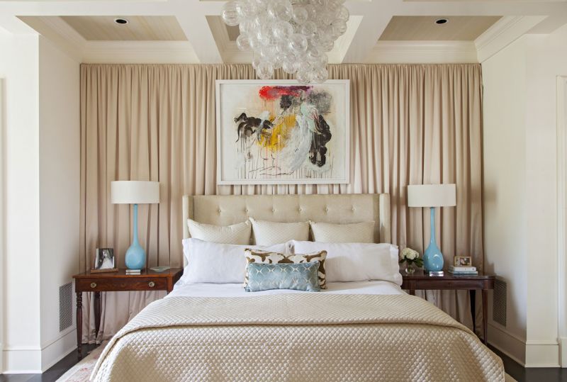 Above the bed, a sculptural chandelier hangs near a colorful abstract piece by local artist Tim Hussey.