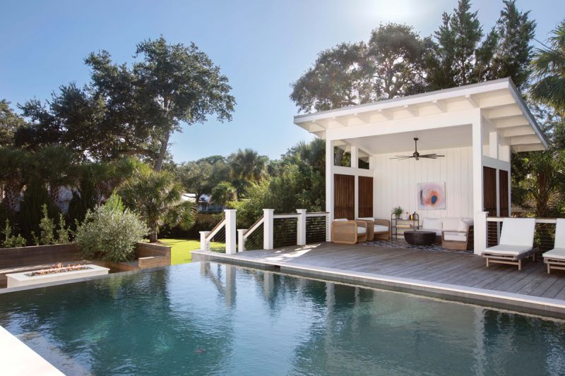 Party in the Back: The backyard, complete with a fire-pit seating area (left), shiplap-covered cabana, and infinity pool wrapped by a Brazilian hardwood deck, provides a perfect play space for kids and adults alike.