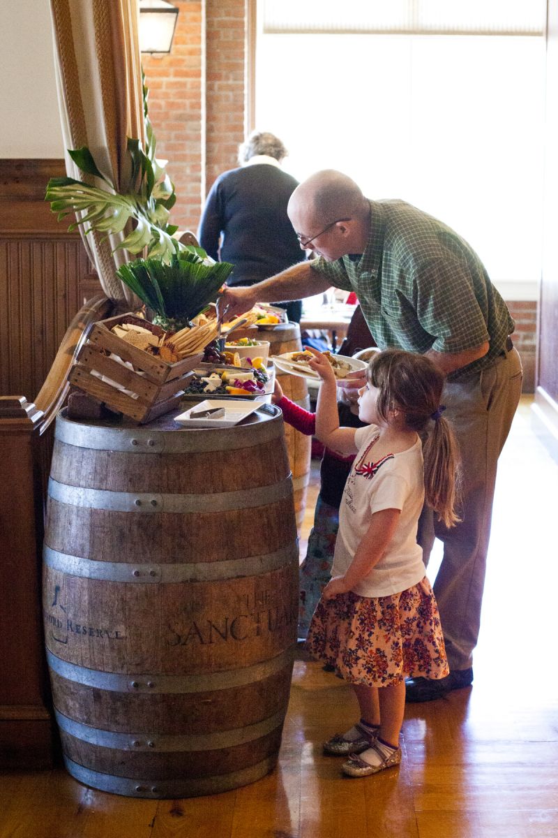 A father helped his daughter to the buffet.