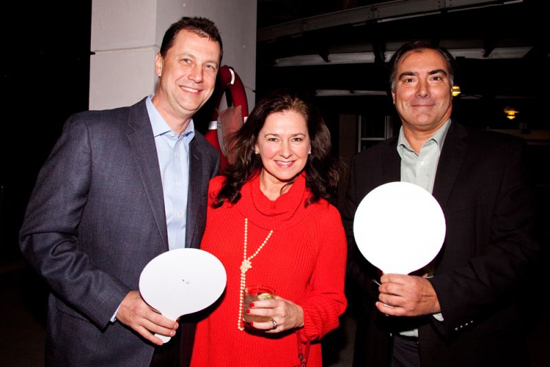 Rowdy and Sonya Harden wielding their auction paddles with Mike Rousseau