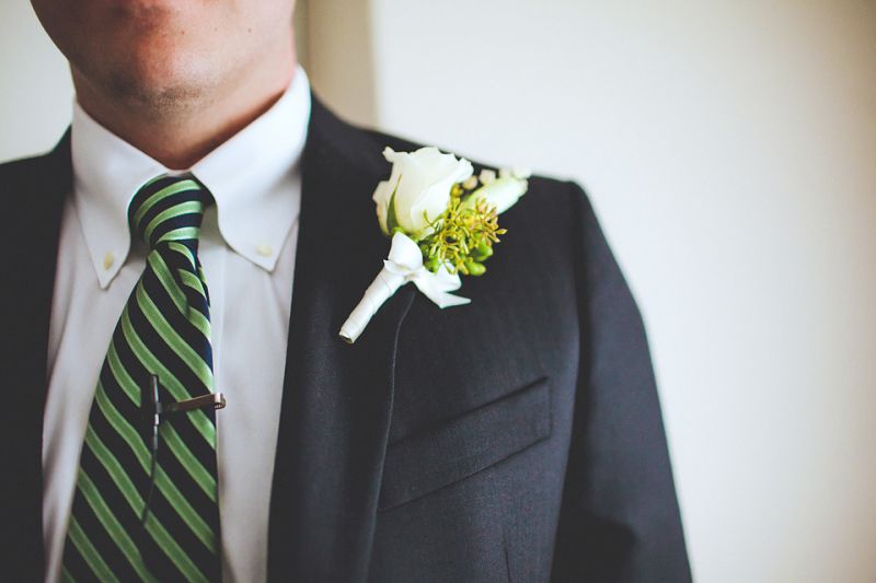 FRESH PICK: For the groom’s boutonniere, Loluma arranged a white rose with simple greens complementing his green and navy striped tie.