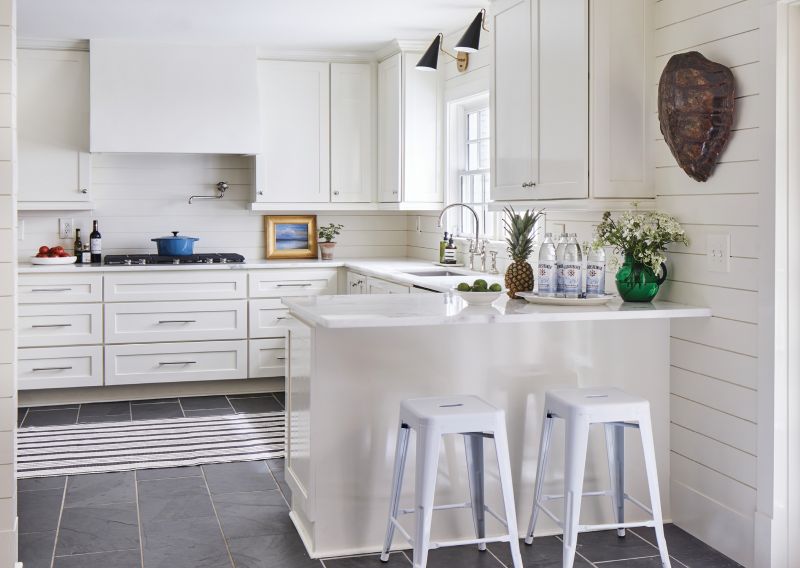 Pick Your Pace: With white shiplap walls, cabinets, and plaster hood, the home’s kitchen is a calm blank slate. “It’s nice to have a space that sort of gives you a break and is more about function—where you can focus on the task of preparing a meal,” says Hewlette.