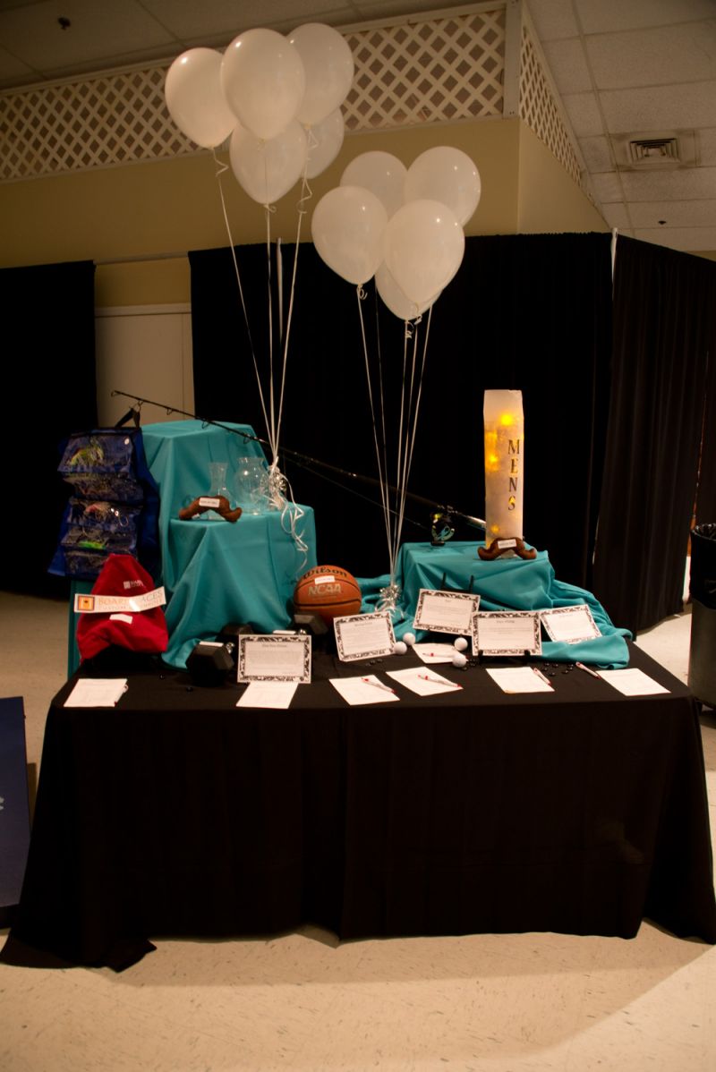 A table of silent auction items catered to men with sports trips, outings, and packages among the items up for grabs.