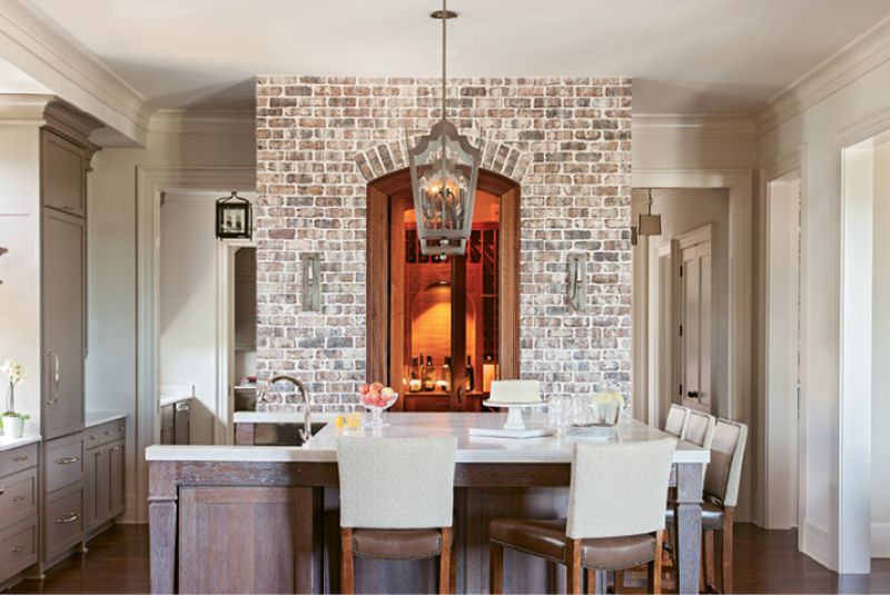 in the mix: Accent walls of brick and butted board help to set a welcoming, laid-back tone, while gilt-framed artwork and fixtures from Circa and Urban Electric add touches of elegance.
