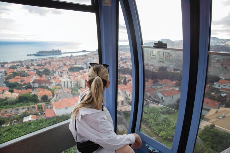 Experiencing Funchal via a cable car that travels nearly two miles as it ascends the city’s steep mountainside.