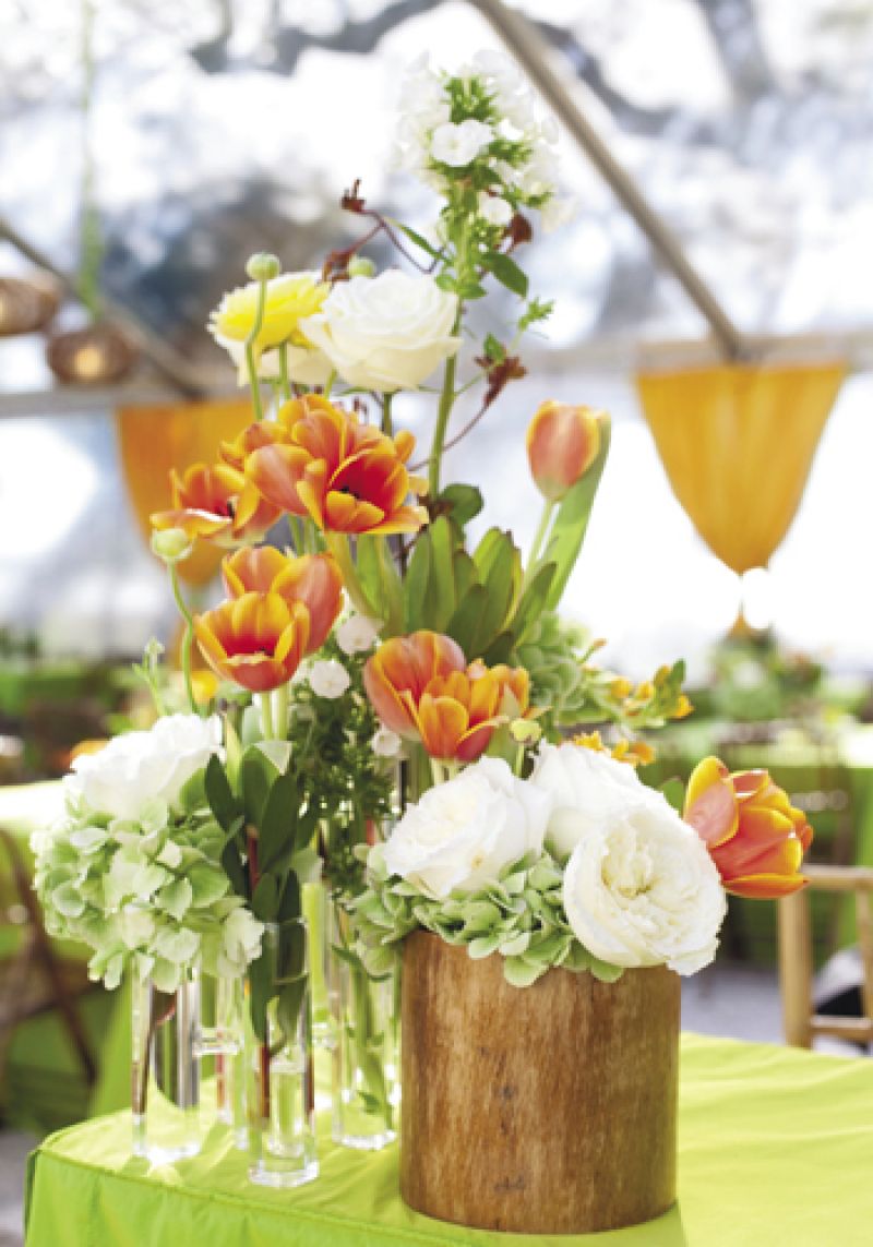 APRIL SHOWERS: Blossoms Events filled glass beakers and wooden cylinders with garden roses, hydrangea, ranunculus, tulips, and more.