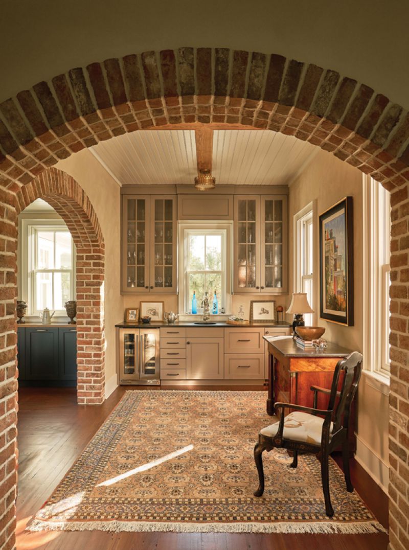 Brick archways lead into the addition through a bar area connecting the wing to the dining room.