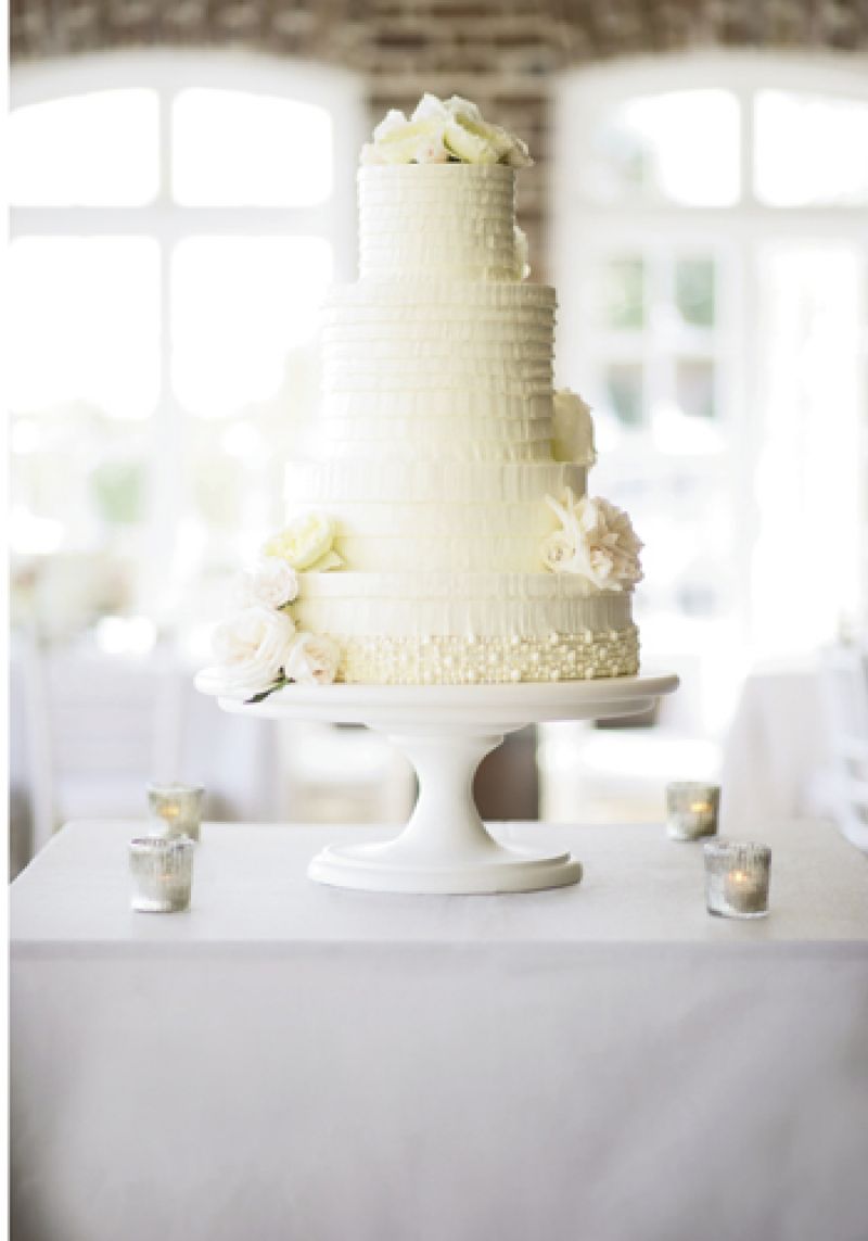 IVORY TOWER: The four-tiered confection by Wedding Cakes by Jim Smeal mimicked the tablescape’s white and cream coloring, the layers of Aly’s Vera Wang gown, and the flora of her bouquet.